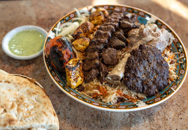 A whole lamb shank, a skewer of tikka kebab, a skewer of chicken kebab a skewer of shami kebab and skewer of chapli kebab from Ariana Afghan Restaurant.