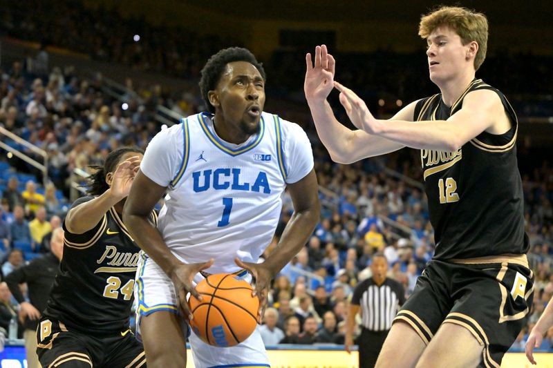 Jan 20, 2026; Los Angeles, California, USA; UCLA Bruins forward Xavier Booker (1) is defended by Purdue Boilermakers guard Gicarri Harris (24) and center Daniel Jacobsen (12) as he drives to the basket in the first half at Pauley Pavilion presented by Wescom Financial. Mandatory Credit: Jayne Kamin-Oncea-Imagn Images