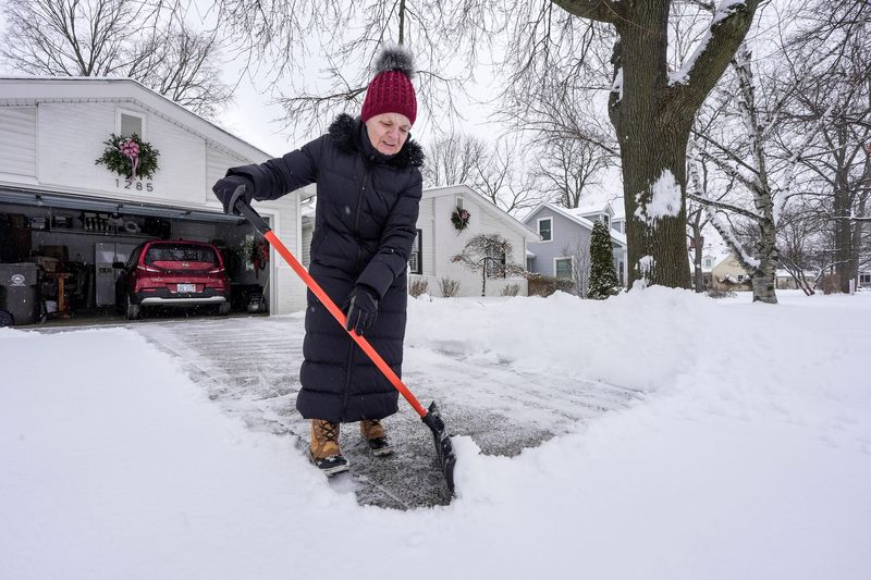 Carol Goode, 78, clears the fresh snow from the driveway of her 1965 bungalow in Plymouth on Wednesday, Jan. 21, 2026. Goode says her son usually comes and shovels the snow for her, since moving in a year and a half ago.