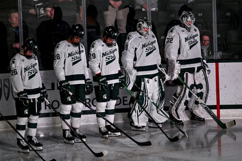 Michigan State players join the entire arena in a moment of silence in honor of MSU hockey staffer Dan Sturges before the game against Minnesota on Friday, Jan. 23, 2026, at Munn Ice Arena in East Lansing.