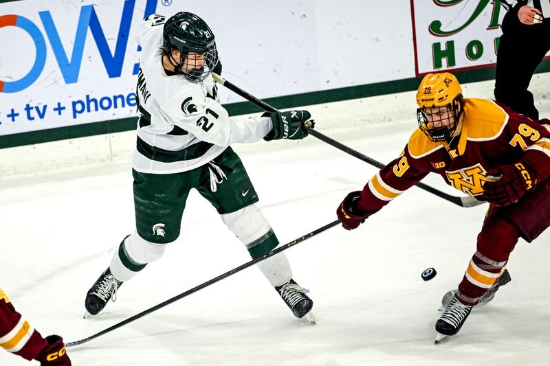 Michigan State's Anthony Romani, left, hits the puck as Minnesota's Mason Moe closes in during the first period on Friday, Jan. 23, 2026, at Munn Ice Arena in East Lansing.