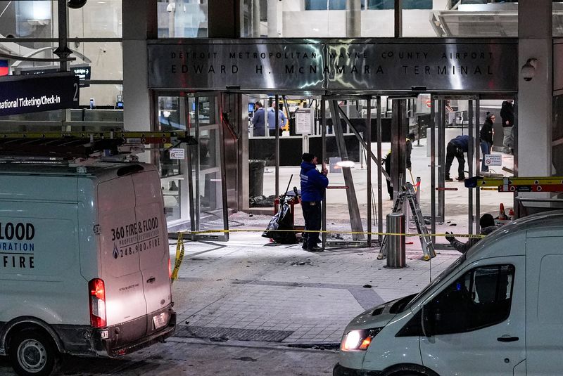 Workers clean up damage near the international ticketing gate of Detroit Metro Airport McNamara Terminal after a car drove into the building in Romulus on Friday, Jan. 23, 2026.