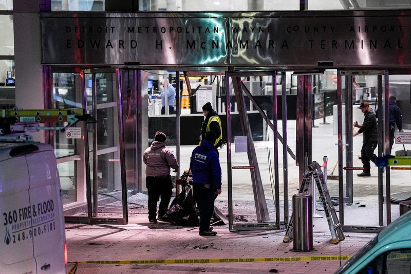 Workers clean up damage near the international ticketing gate of Detroit Metro Airport McNamara Terminal after a car drove into the building in Romulus on Friday, Jan. 23, 2026.