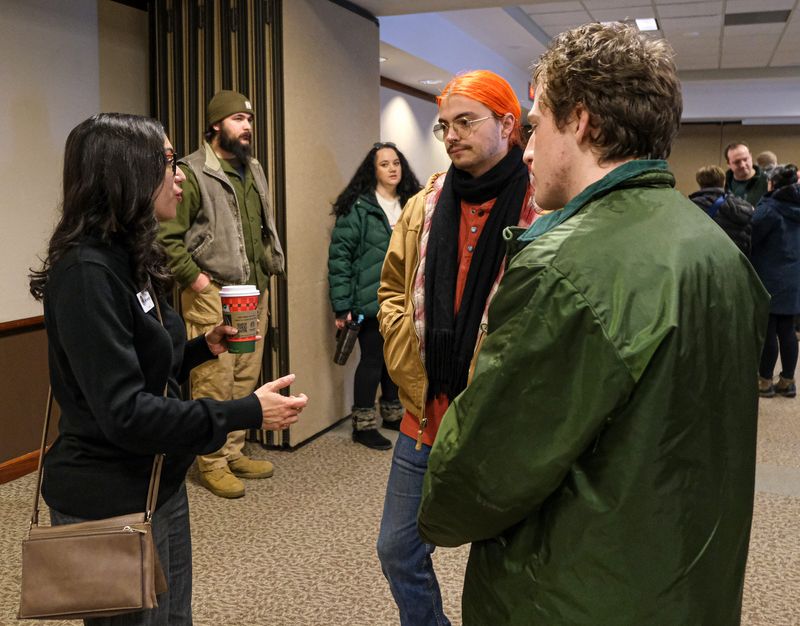 Trini Pehlivanoglu, an at-large Lansing City Councilmember, speaks to Henry Jarred, right, and Jacob Robins at the public meeting at the Lansing Center about the proposed Deep Green data center for downtown Lansing Saturday, Jan. 24, 2026.