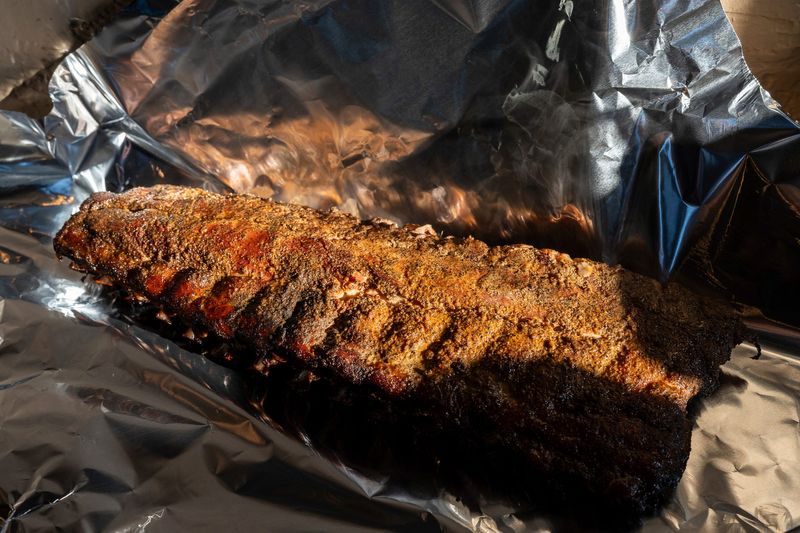 A rack of ribs rests in foil inside Blue Kuna Smokehouse in Plymouth on Friday, Jan. 23, 2026.
