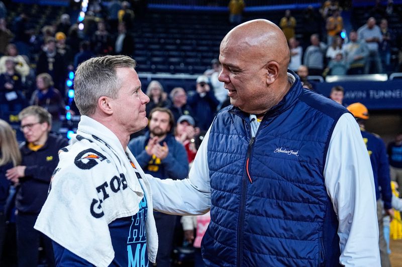 Michigan head coach Dusty May, left, is congratulated by athletic director Warde Manuel after 75-72 win over Nebraska at Crisler Center in Ann Arbor on Tuesday, Jan. 27, 2026.