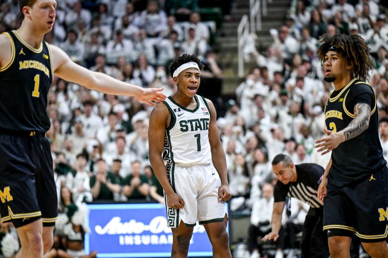 Michigan State's Jeremy Fears Jr., center, jaws with Michigan's Tre Donaldson, right, after Fears hit a ball off Donaldson and out of bounds during the first half on Sunday, March 9, 2025, at the Breslin Center in East Lansing.