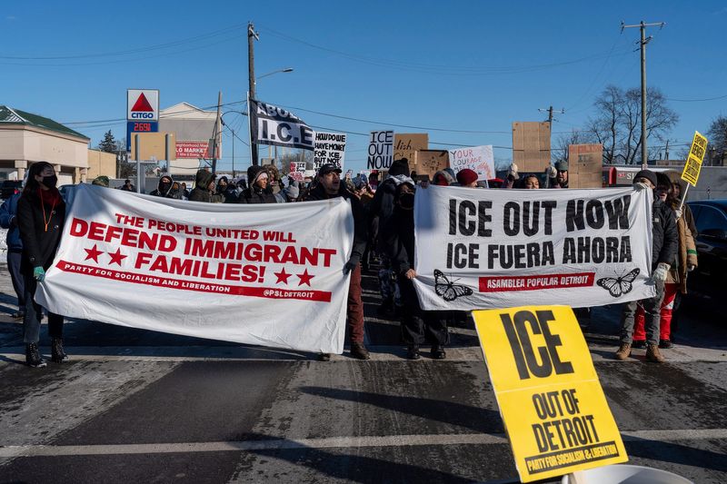Protesters holding banners and signs march during a demonstration led by the Party for Socialism and Liberation Detroit in Detroit on Friday, Jan. 30, 2026.