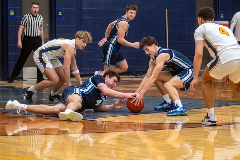 Petoskey's Lukas Nemec (left) and Rider Bartel (right) lay out for a loose ball late in the game during a 51-40 win over Gaylord on Friday, Jan. 30.