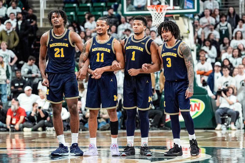 From left, Michigan forward Morez Johnson Jr. (21), guard Roddy Gayle Jr. (11), guard Trey McKenney (1) and guard Elliot Cadeau (3) locks arms to watch forward Yaxel Lendeborg (not in the photo) shoot free throw against Michigan State during the second half at Breslin Center in East Lansing on Friday, Jan. 30, 2026.