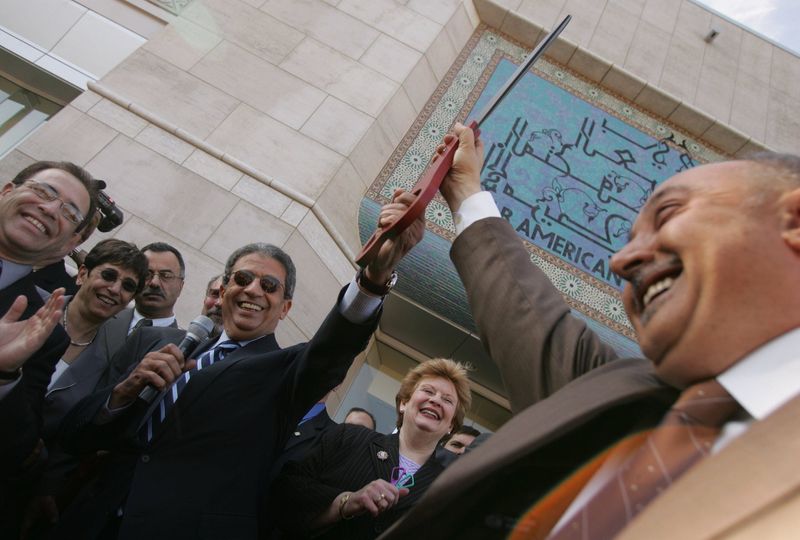 Secretary General of the League of Arab States Amre Moussa, left, hands scissors to Ismael Ahmed CQ after the ribbon cutting to open the Arab American National Museum in Dearborn, Mich., Thursday, May 5, 2005. Michigan's US Senator Debbie Stabenow is at center. Wayne County Executive Robert Ficano is at far left.