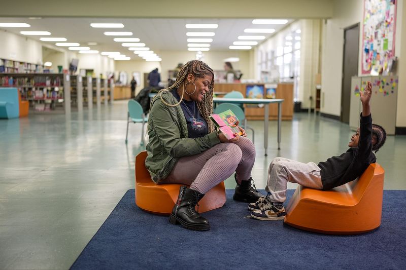Symone Wilkes, 34, of Detroit reads a book to her youngest son Dy’Lan Williams, 4, at the Thomas A. Edison Detroit Public Library branch in Detroit after picking up her 8-year-old son from school, on Wednesday, Jan. 29, 2026.