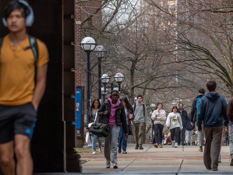 People walk near The Diag on the University of Michigan campus in Ann Arbor on Friday, March 28, 2025.