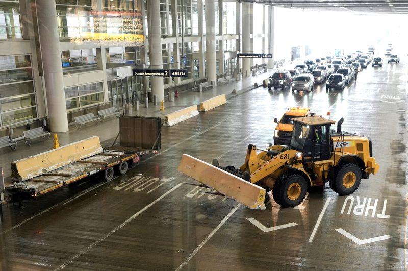 Long concrete barriers are taken off a truck and placed in front of doors at baggage claim at the McNamara Terminal at Detroit Metro Airport on Tuesday, Feb. 3, 2026.
On Jan. 23, 2026, a small SUV drove up and crashed through the glass doors on the departure level above by the Delta international check in. Barriers are being put in place to make sure that kind of thing can’t happen again.