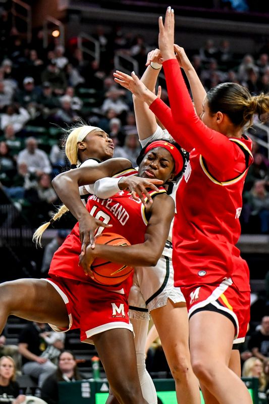 Maryland's Mir McLean, center, gets a rebound over Michigan State's Jalyn Brown, left, during the third quarter on Wednesday, Feb. 4, 2026, at the Breslin Center in East Lansing.