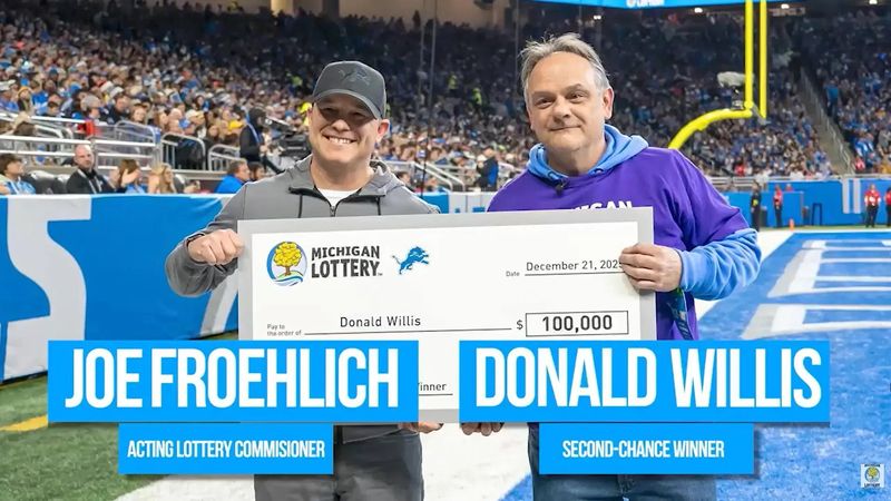 Acting Lottery Commissioner Joe Froehlich, left, presenting Donald Willis with his $100,000 check at the Detroit Lions Second Chance event