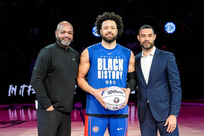 From left, Detroit Pistons head coach J.B. Bickerstaff, guard Cade Cunningham and president of basketball operations Trajan Langdon honored on the court before tipoff against New York Knicks at Little Caesars Arena in Detroit on Friday, February 6, 2026.