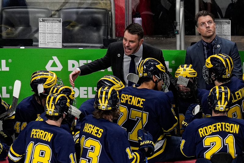 Michigan head coach Brandon Naurato talks to players at a timeout against Michigan State during the second period of Duel in the D at Little Caesars Arena in Detroit on Saturday, February 7, 2026.