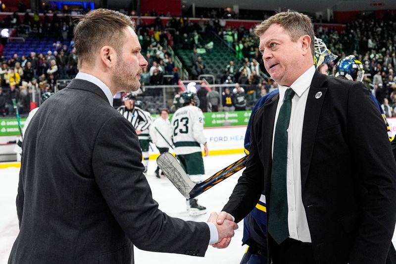 Michigan head coach Brandon Naurato, left, shakes hands with Michigan State head coach Adam Nightingale after 5-2 loss at the Duel in the D at Little Caesars Arena in Detroit on Saturday, February 7, 2026.