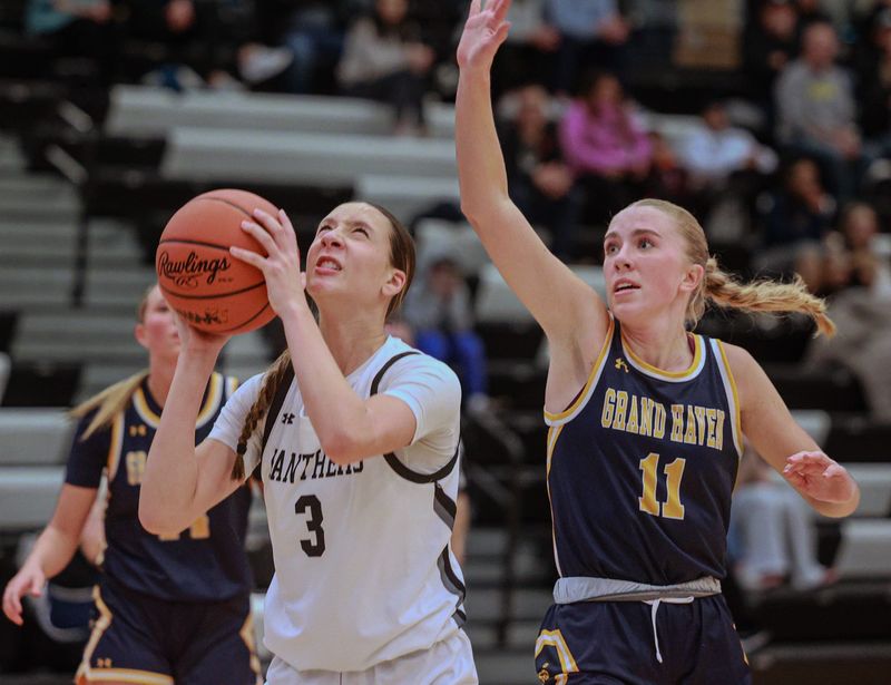 West Ottawa's Jana Honeycutt goes up for a shot against Grand Haven's Kendall Gillis on Feb. 10.