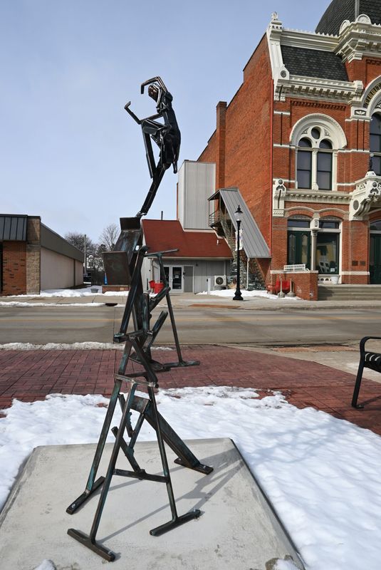 The six-foot high “Balanced Beams” sculpture drew praise, criticism, and questions in the sidewalk park across from Tibbits Opera House.