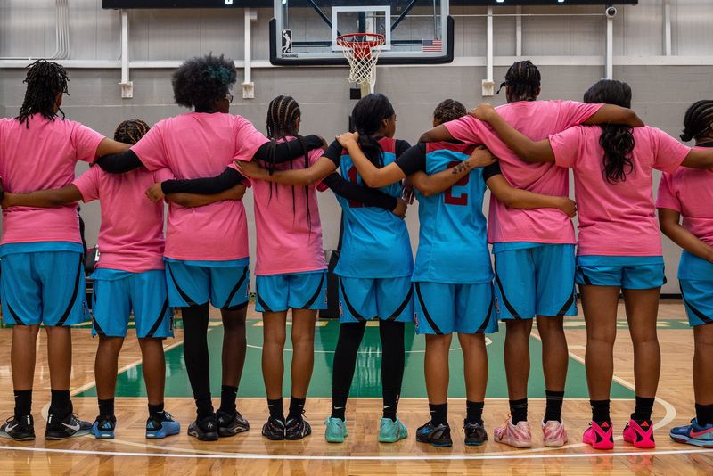 Mumford High School players stand arm in arm during pregame introductions during the Detroit Public School League girls basketball championship game against Renaissance High School at Wayne State Fieldhouse in Detroit on Sunday, Feb. 15, 2026.