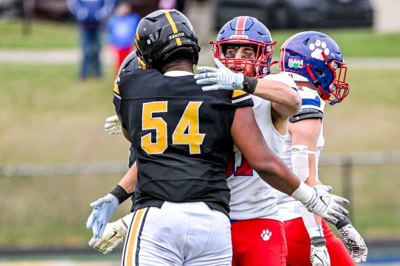 Mason's Jacob Ackley, right, and Detroit King's Jameer Henry hug after the state semifinal game on Saturday, Nov. 23, 2024, at Chelsea High School.