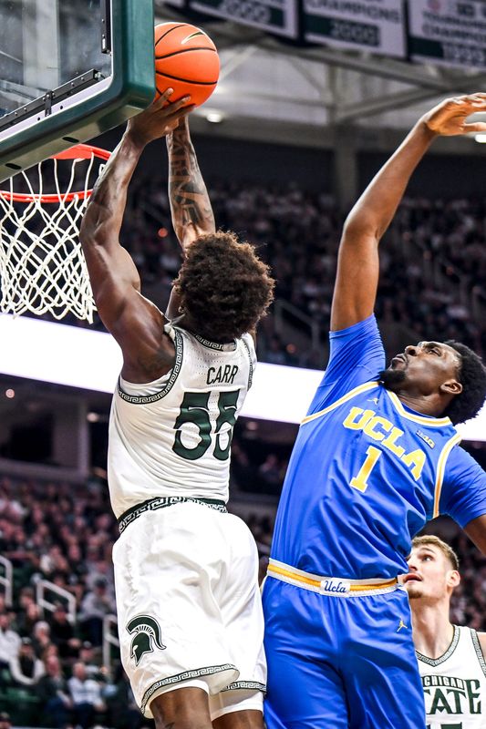 Michigan State's Coen Carr, left, dunks as UCLA's Xavier Booker defends during the first half on Tuesday, Feb. 17, 2026, at the Breslin Center in East Lansing.