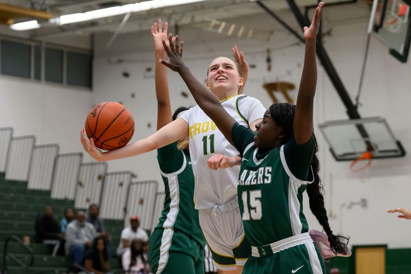 Groves' Sophia Schwanik tries to score while being defended by West Bloomfield's Lia Taylor, right, in the second half of a basketball game between West Bloomfield and Birmingham Groves, at Groves high school, in Birmingham, February 17, 2026.
