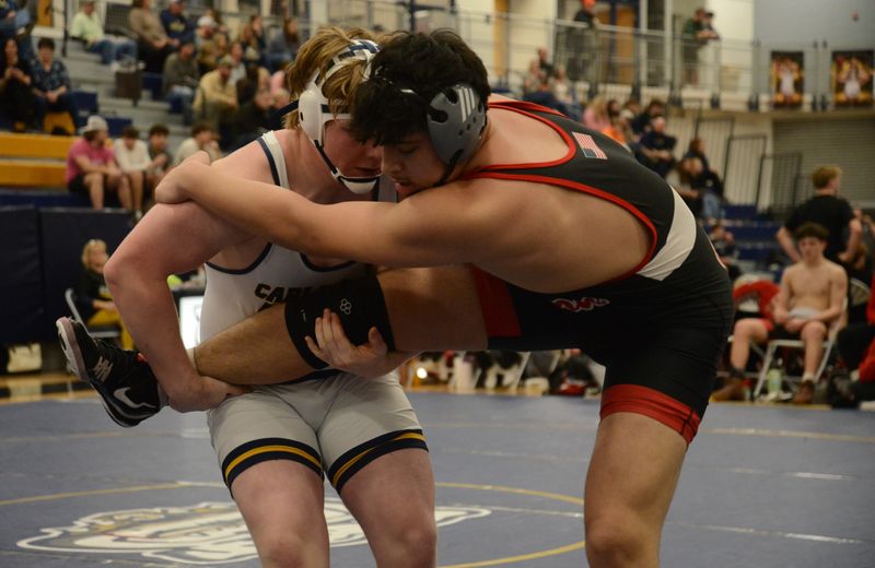 Airport's Holden Otter lifts the leg of Malik Al-Zayadi of New Boston Huron at 285 pounds in the semifinals of the Division 2 Team Regional at Chelsea on Wednesday, Feb. 18, 2026.