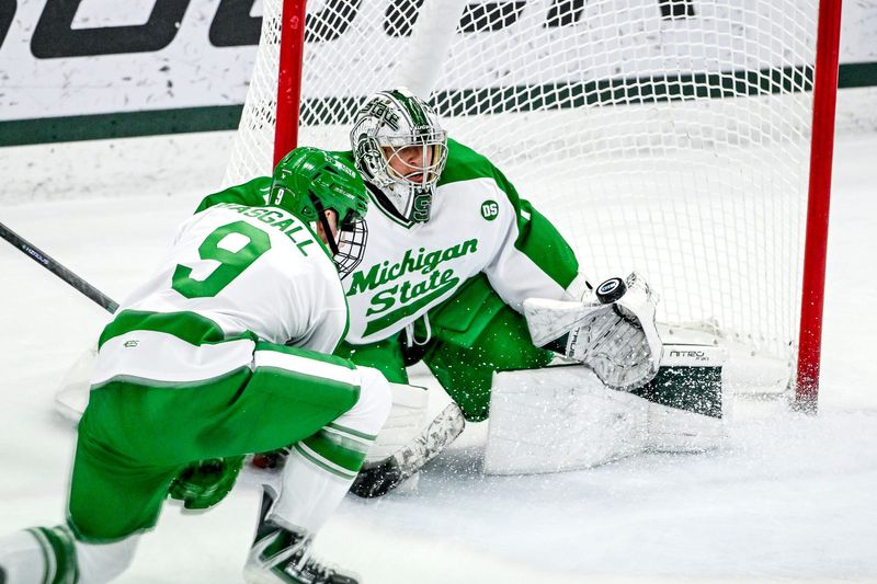 Michigan State's Trey Augustine, right, deflects a Notre Dame shot during the first period on Thursday, Feb. 19, 2026, at the Munn Ice Arena in East Lansing.