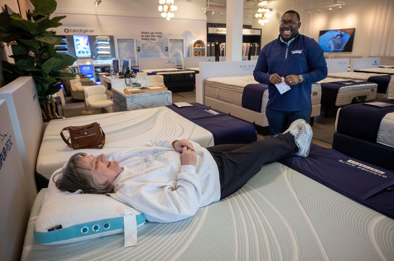 Carlene Schaaf of Riverview, tries out a mattress with the help of store manager Troy Tidwell at the Gardner White mattress store in Woodhaven on Monday, Feb. 23, 2026. The recently opened store reflects the longtime furniture seller's strategy to expand and move into new market niches.