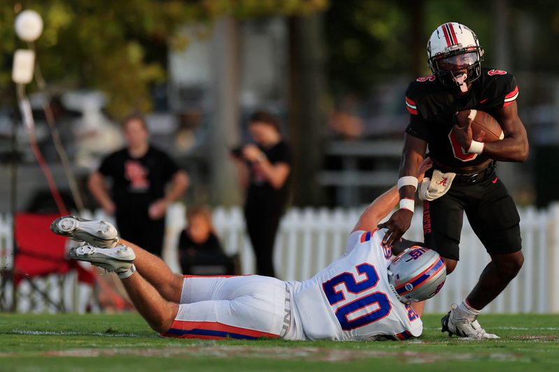 Bishop Kenny's Caleb Mattison (6) avoids a tackle from Bolles' Thomas Green (20) during the first quarter of a high school football matchup at Bishop Kenny High School, Friday, Sept. 12, 2025, in Jacksonville, Fla. The Bolles Bulldogs blanked the Bishop Kenny Crusaders 36-0.