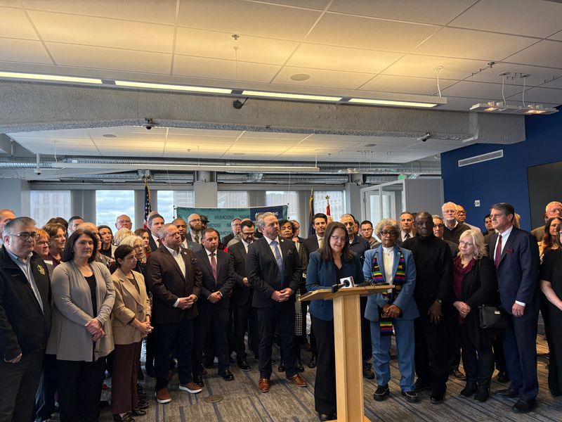 Dozens of municipal and township officials from across Metro Detroit gather at a press conference Tuesday in Detroit to oppose proposed state legislation that they contend will restrict their ability to make local zoning decisions.