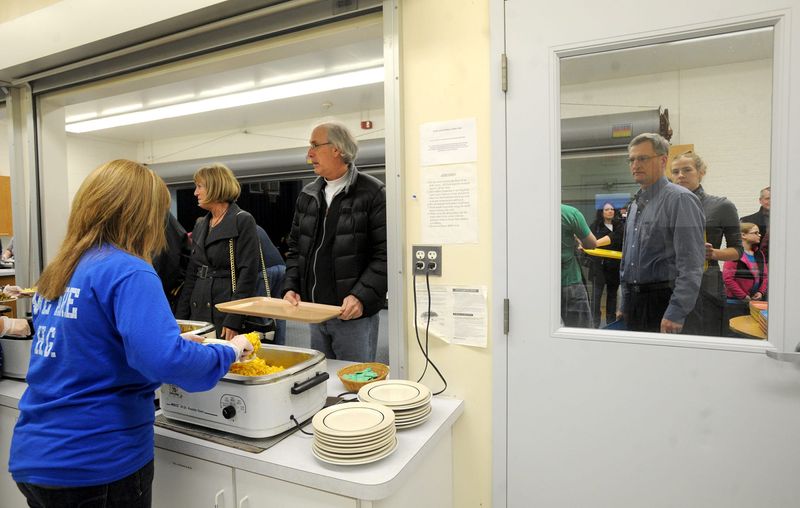 Trays in hand, diners lined up at the entree serving station during a previous year's fish fry at Holy Ghost Lutheran Church and School in Monroe.