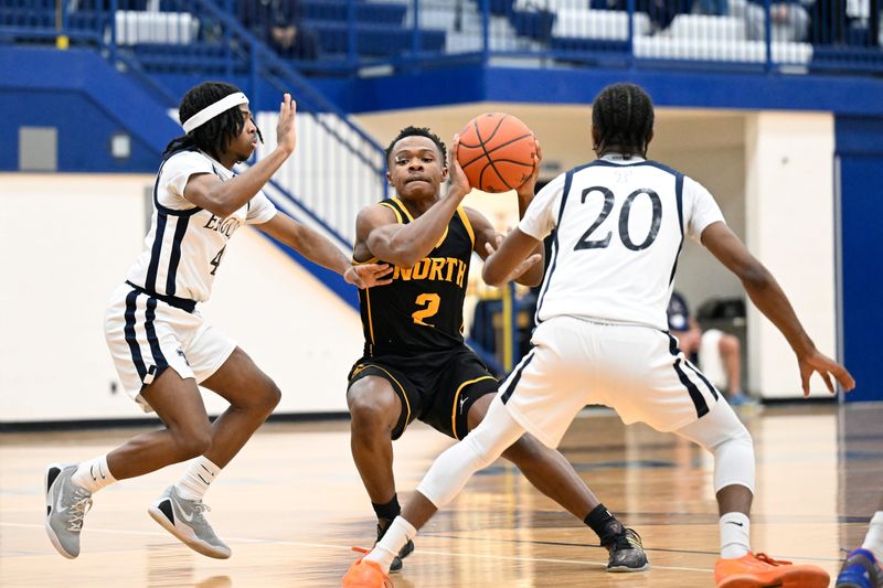 North Farmington guard Quran Creary, middle, is defended by Redford Thurston guard Terran Johnson, left, and guard James Pitts during the first half, Wednesday, Feb. 25, 2026, in an MHSAA district semifinal game held at Adlai E. Stevenson HS in Livonia, Mich. (Jose Juarez/Special to Detroit News)
