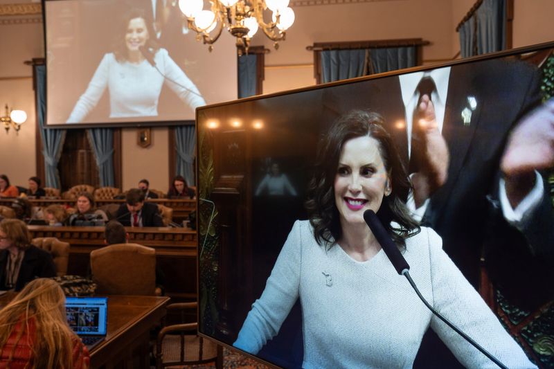 Gov. Gretchen Whitmer is seen on screens as members of the media work while she speaks during her eighth and final State of the State address at the Michigan Capitol Building in Lansing on Wednesday, February 25, 2026.