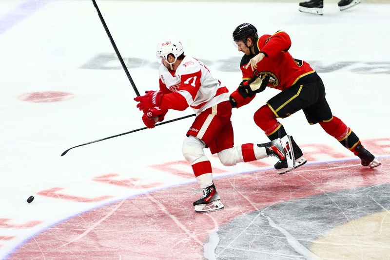Detroit Red Wings center Dylan Larkin (71) and Ottawa Senators defenseman Jake Sanderson (85) chase the puck during the third period at Canadian Tire Centre in Ottawa on Thursday, Feb. 26, 2026.