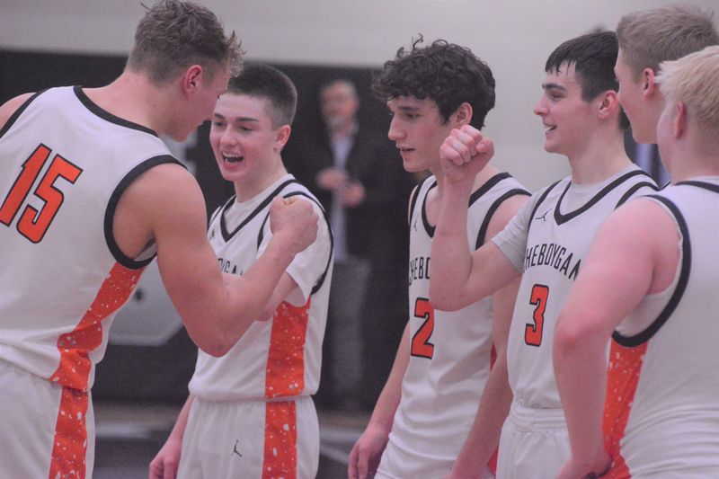Cheboygan players, including Nolan Schley (15), Landon Gahn (second from left), Carson Kiefer (2) and Gavin Smith (3), celebrate as they were being honored for winning an MHSAA Division 2 boys basketball district title on Friday, Feb. 27.