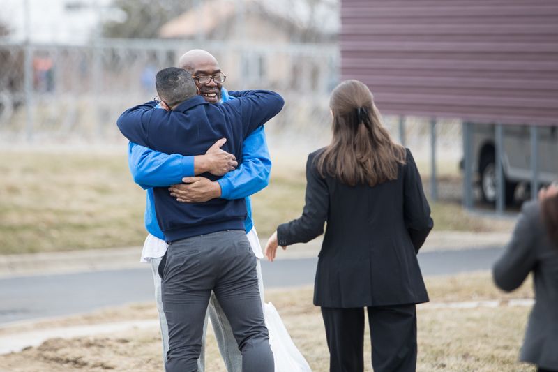 George Calicut, center, hugs one of the University of Michigan law students working with him after he is released from prison March 3, 2026, after serving 27 years for a murder he did not commit.