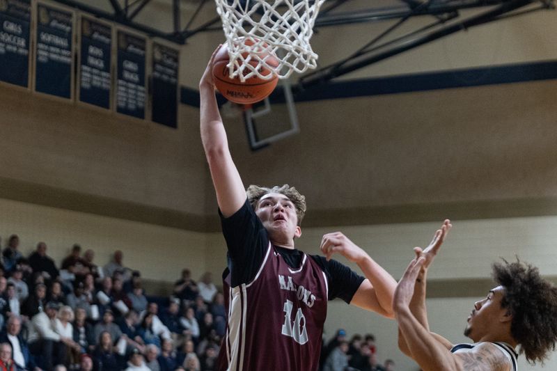 Holland Christian's Jake Holcomb goes up for the dunk against Niles on Tuesday, March 3.