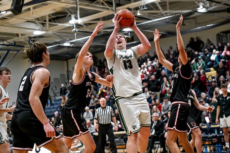 Freeland's Tristan Comer, center, scores against Portland during the third quarter on Tuesday, March 3, 2026, at Owosso High School.
