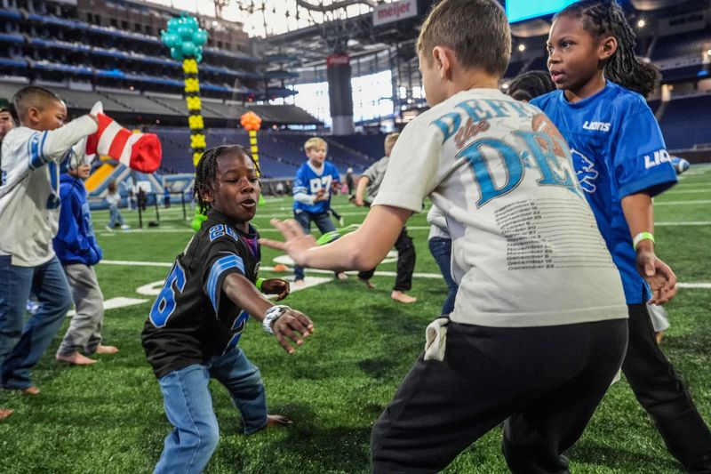 Chase Schneider, 8, of Clinton Twp., tries to grab a sock from a competitor during a game of Shark Tank during the Detroit Lions’ Tackle Reading event at Ford Field in celebration of Dr. Seuss’s 122nd birthday, featuring literacy-focused activities and on-field “Seuss Olympic” games in Detroit on Wednesday, March 4, 2026.