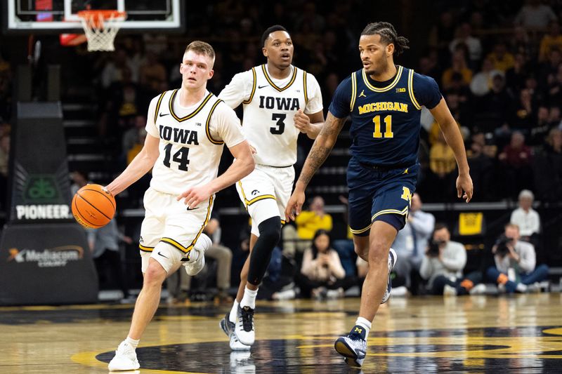 Iowa guard Bennett Stirtz brings the ball up court against Michigan guard Roddy Gayle Jr. as Iowa forward Cam Manyawu follows at Carver-Hawkeye Arena in Iowa City, Iowa, on March 5, 2026.