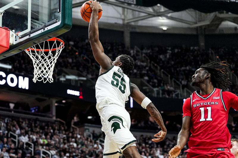 Michigan State forward Coen Carr (55) dunks against Rutgers forward Chris Nwuli (11) during the second half at Breslin Center in East Lansing on Thursday, March 5, 2026.