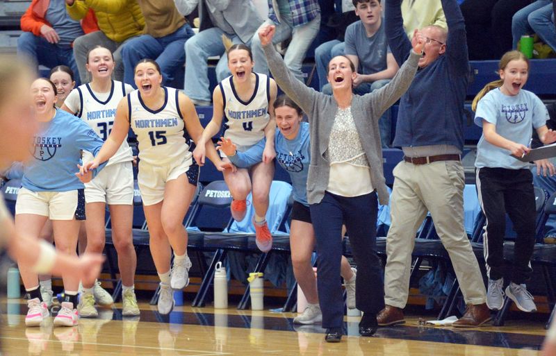 Petoskey head coach Brooke Carlson and others along the Northmen bench erupt as the final buzzer rings out and a 59-57 victory reads on the PHS scoreboards against Sault Ste. Marie on Friday, March 6.