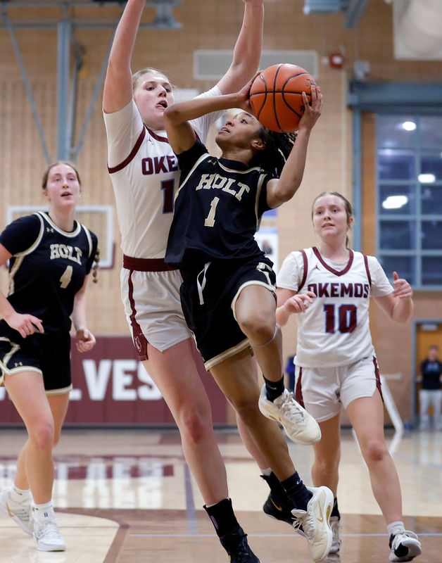 Holt's Victoria Palmer (1) goes up for a shot against Okemos' Savanna Scarlett, Friday, March 6, 2026, in Okemos.