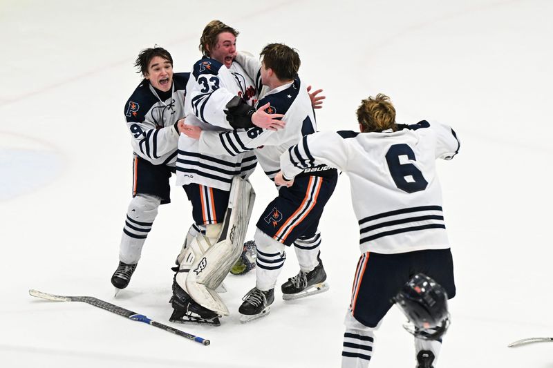 Flint Powers Catholic goalie Hunter Clark (33) celebrates with teammates Owen Perry (9) Ayden Cook (16) and Ethan Haley (6) after defeating Livonia Stevenson, 4-1.