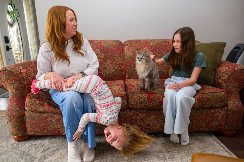 Colon cancer survivor Britta Wofford, 46, of St. Clair Shores spends time with two of her three daughters -- Juliette, 4, and Elliana, 10 -- and their 21-year-old car, Riley. Wofford is among the people affected by the surge in colorectal cancer rates among those under the age of 50.