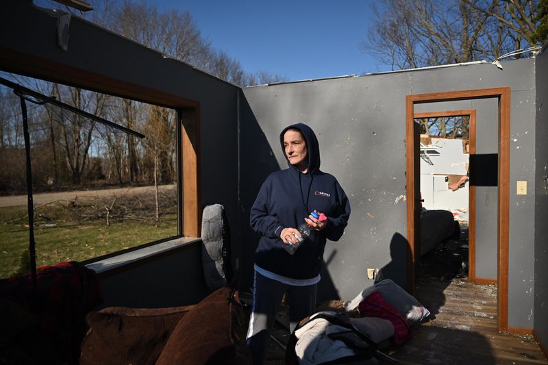 Lena Barfell stands Sunday, March 8, 2026, in the house that she and her husband bought two months ago on Tuttle Road near Union Lake. They were inside when an EF3 tornado hit Friday.